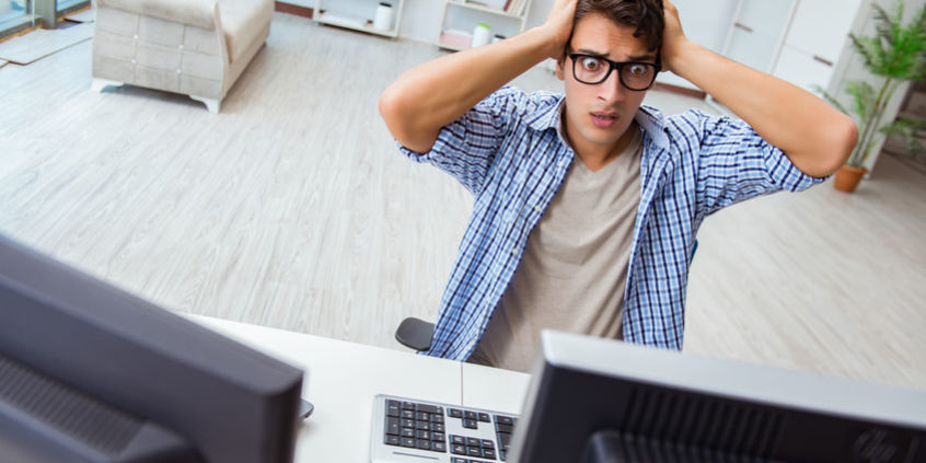 Young trader monitoring markets on screens trading volatile markets