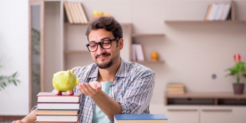 175561614_m young man with books and a piggy bank | improve your options trading skills