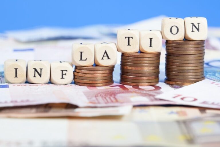 blocks spelling out inflation on stack of money | federal reserve's warnings