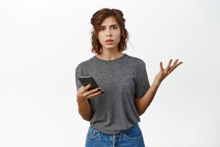 shrugging woman holding smartphone | price and volatility