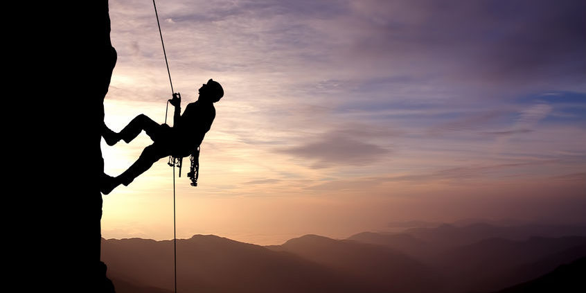 Silhouette of Rock Climber at Sunset rock climber looking up vertical wall | sentiment
