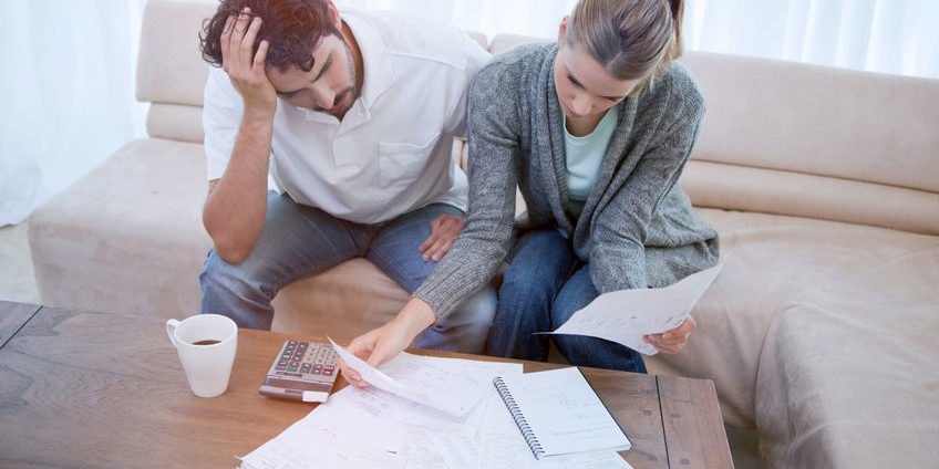 Depressed couple doing their accounting recession
