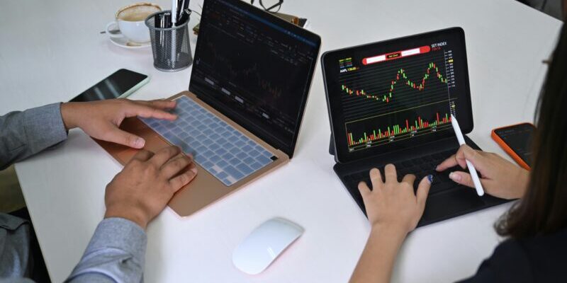 two people trading on their laptops | year end trading strategies