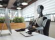 robot sitting at computer | ai trading models versus humans