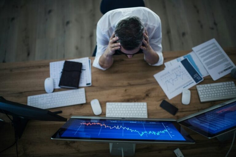 worried trader holding head | low vix reading
