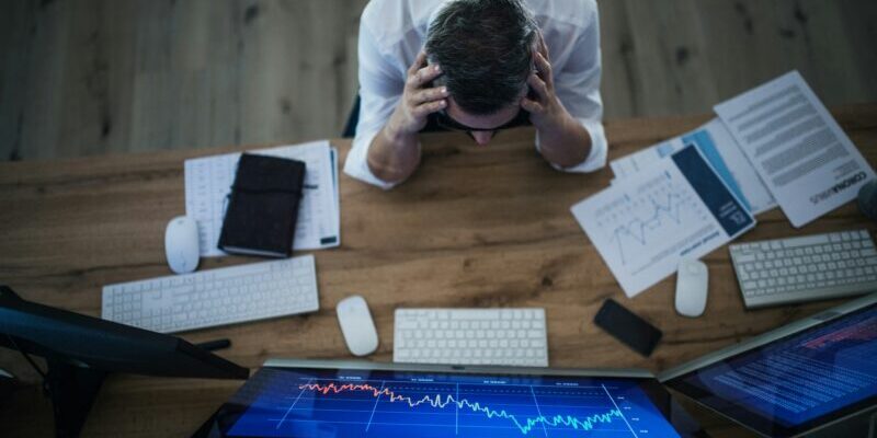 worried trader holding head | low vix reading