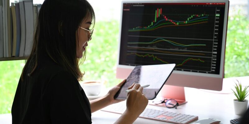 female trader looking at a tablet | sell stocks or options