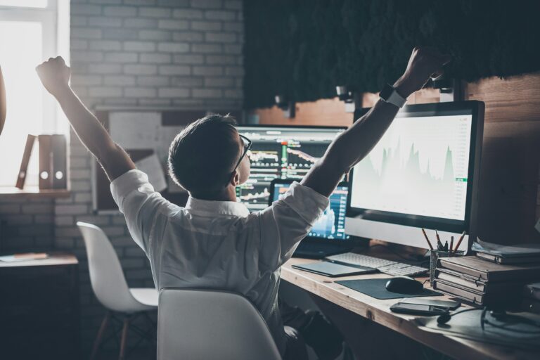 getty-images-TT8I98-jEoc-unsplash trader at desk raising arms in victory | bullish stock market signal