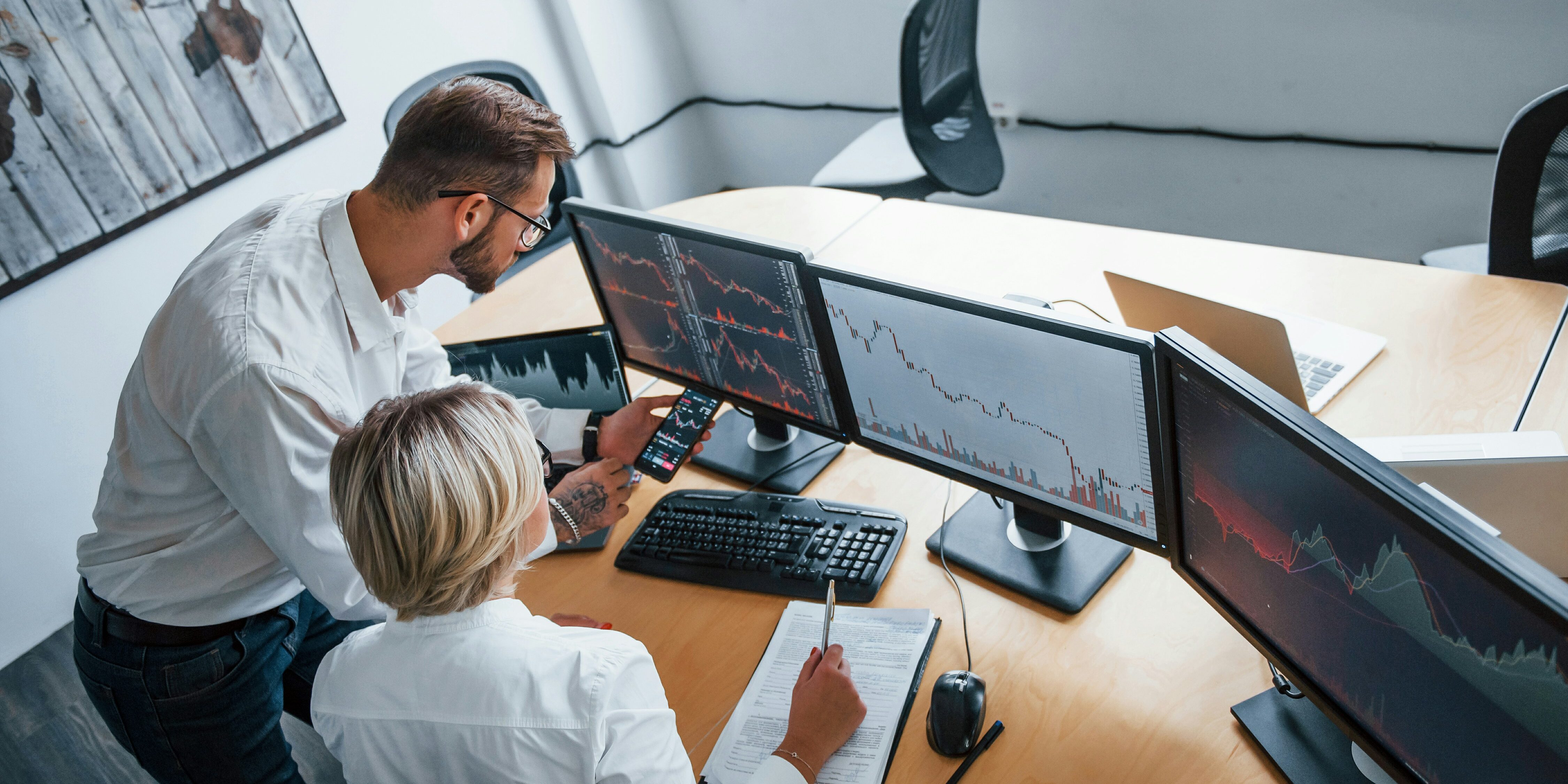 getty-images-hh8GRkdwGo4-unsplash man and woman studying charts on monitors | trading indicators