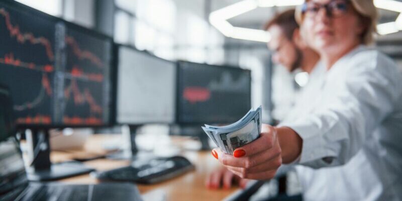 getty-images-kYeTEZukgw8-unsplash woman trader holding a wad of cash | theta