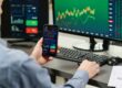 man trading using moible phone and multiple screens | best indicators for day trading