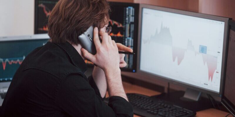 man on phone looking at chart | bond market 101