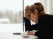 woman holding head, worried about money | big trading risks