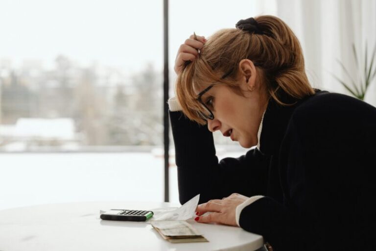 woman holding head, worried about money | big trading risks