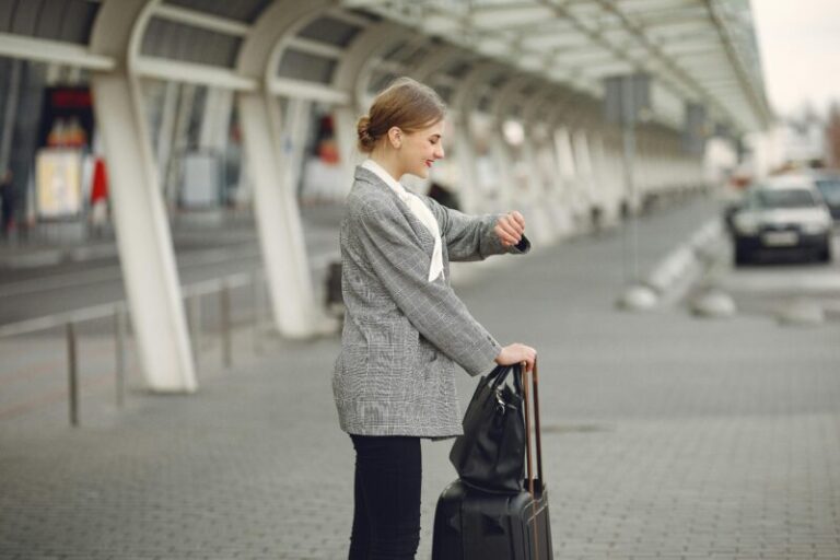 business woman with luggage checking the time | sell in May and go away