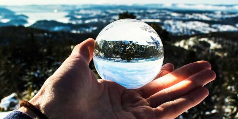 Crazy stock market predictions | man holding a crystal ball