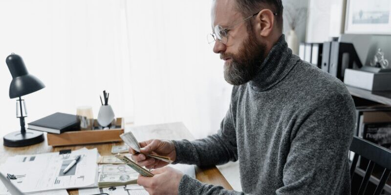 pexels-tima-miroshnichenko-6693644 man counting money | options trading win rate